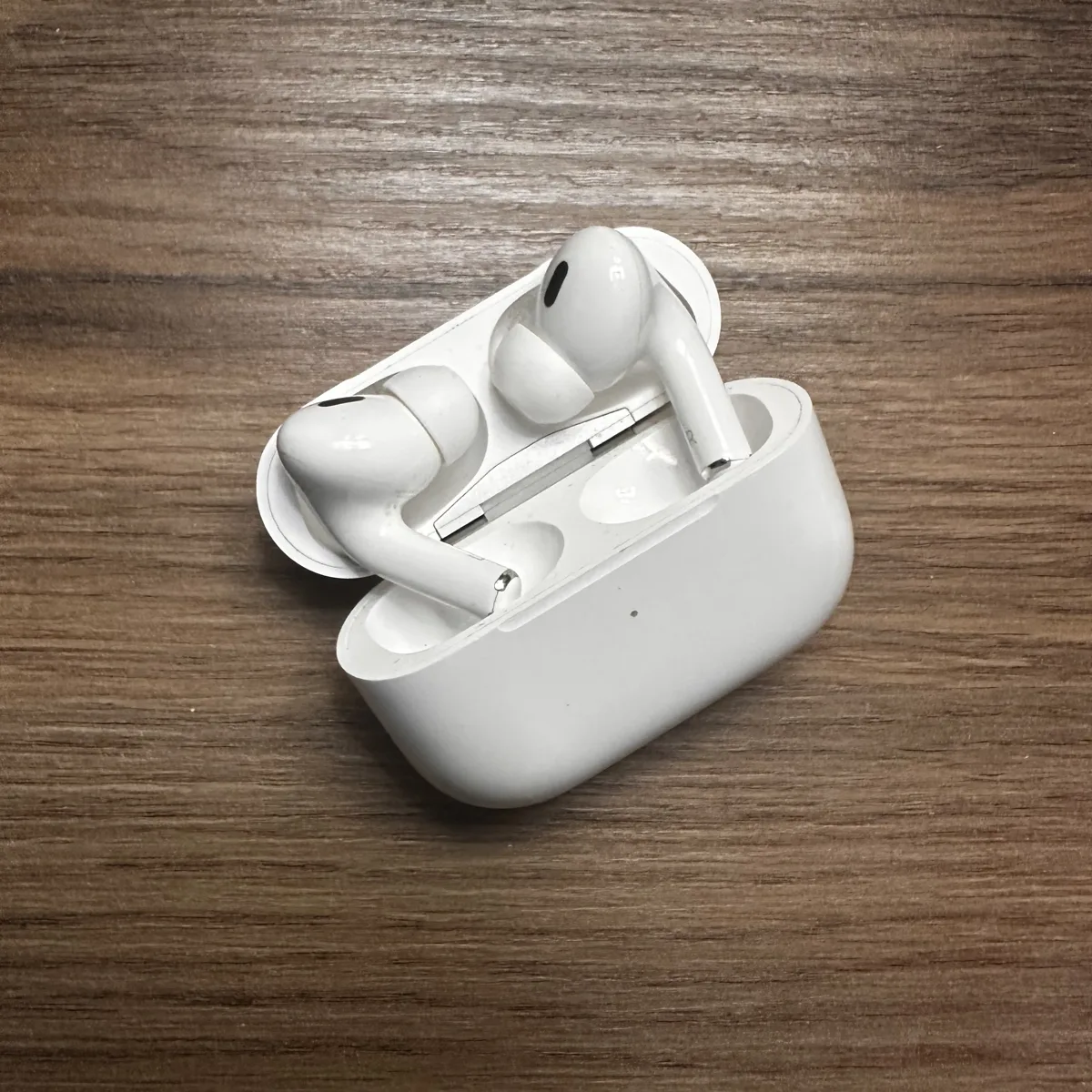 A product photo straight from a phone camera, on a wooden table, not yet cropped to square.